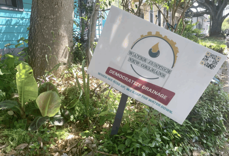 A sign calling for a more equitable approach to drainage stands in a yard in New Orleans' Seventh Ward neighborhood.